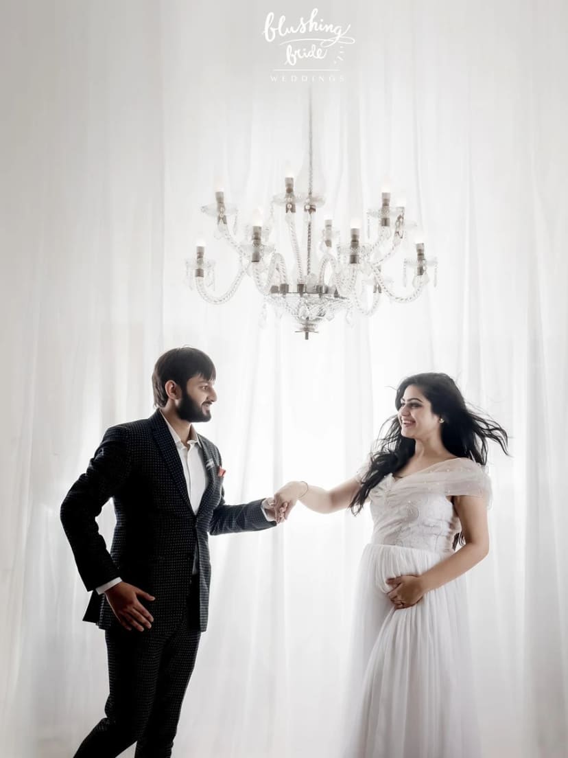 Maternity photography by Blushing Bride, an expectant couple photographed against white drapes